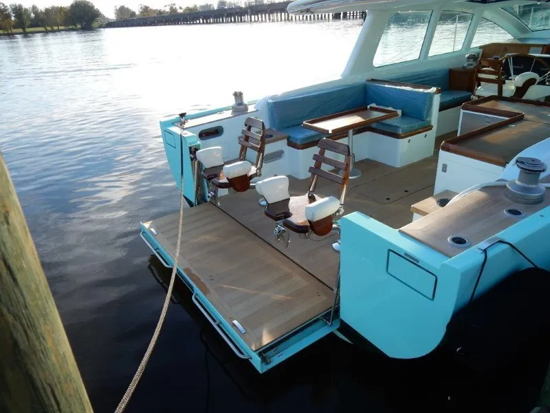 Slide: The Image of Luxurious 2025 Surfari 50 yacht with spacious deck and seating, docked by calm waters. - 26