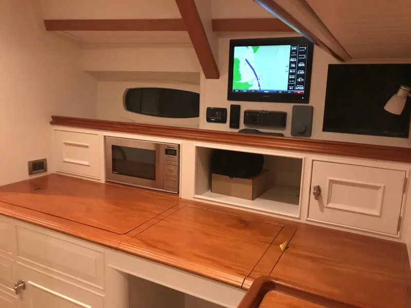 Slide: The Image of Interior of 2025 Surfari 50 yacht with wooden countertop, microwave, and navigation screen. - 39