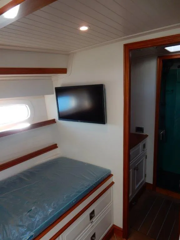 Slide: The Image of Modern cabin interior of 2025 Surfari 50 yacht with bed, TV, and wooden accents. - 44
