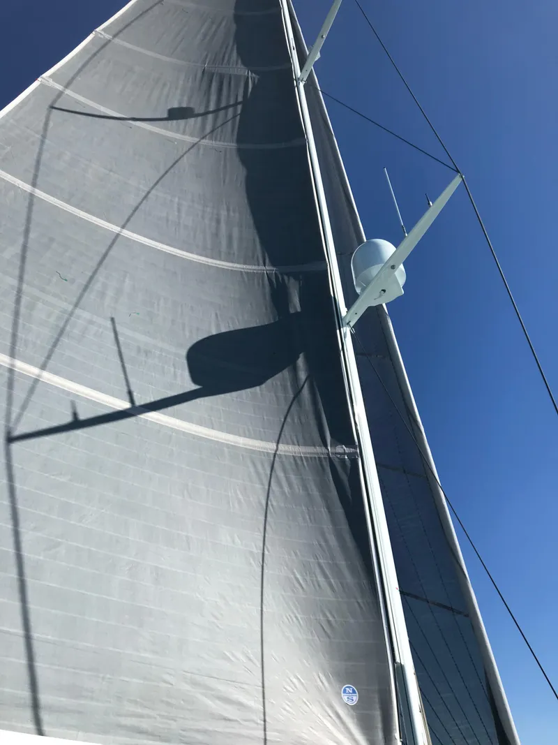 Slide: The Image of Sail of a 2025 Surfari 50 yacht against a clear blue sky. - 46