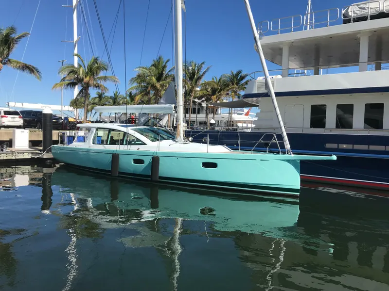 Slide: The Image of 2025 Surfari 50 yacht docked in marina, surrounded by palm trees and clear blue sky. - 9