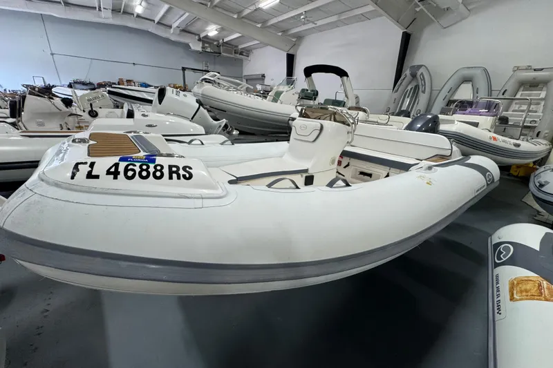The Image of 2018 Walker Bay Generation 450 DLX inflatable boat in showroom, featuring sleek design and Florida registration. - 0