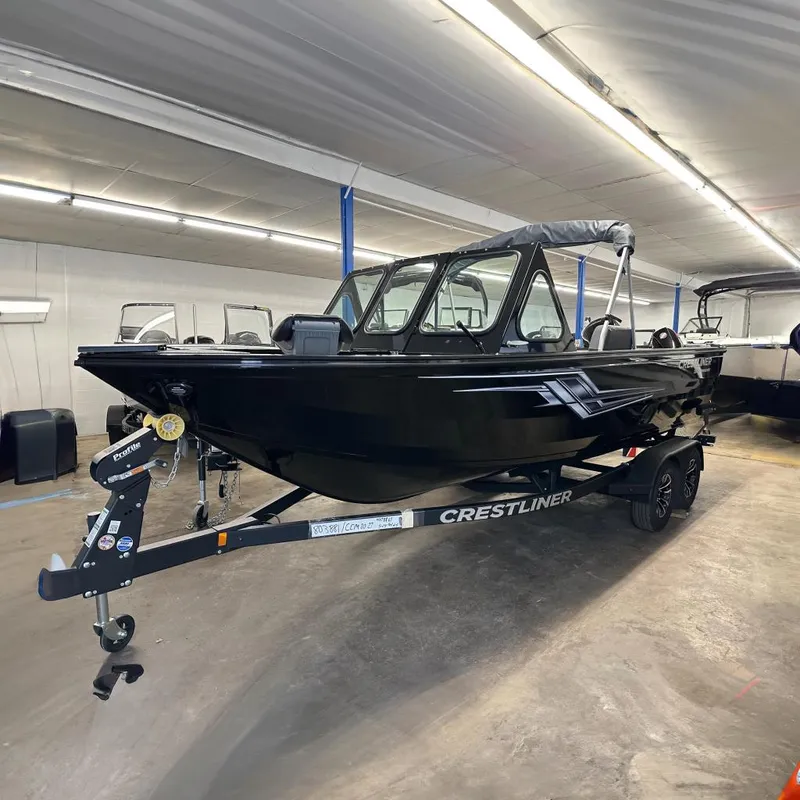 The Image of 2026 Crestliner 2050 Commander boat in showroom, black exterior, on trailer. - 0