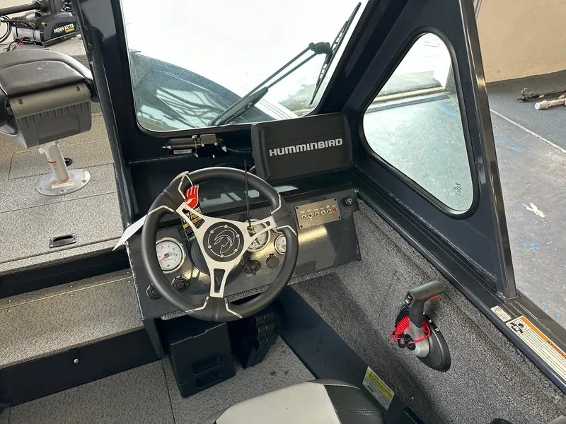 Slide: The Image of 2025 Crestliner 2050 Commander boat cockpit with steering wheel and Humminbird electronics. - 3