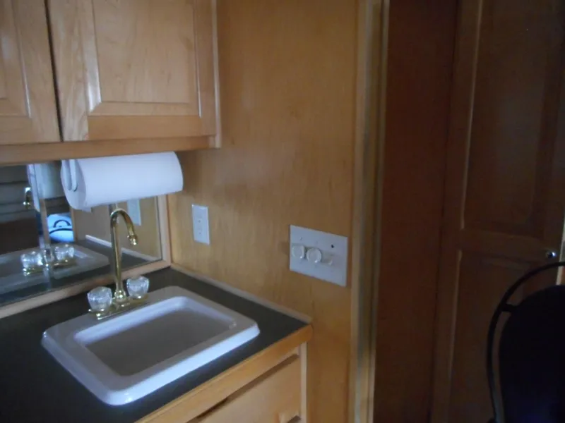 Slide: The Image of 2003 Stardust Cruisers Summer Haven Trip 33 kitchen sink area with wooden cabinets. - 21