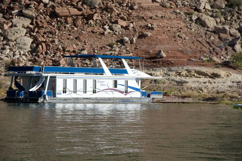 Slide: The Image of 2003 Stardust Cruisers Summer Haven Trip 33 houseboat docked by rocky shoreline. - 40