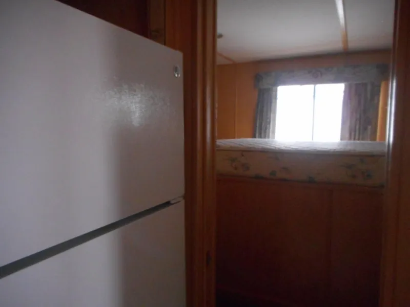 Slide: The Image of Interior of 2003 Stardust Cruisers Summer Haven Share #34 & 35, showing refrigerator and bedroom. - 16