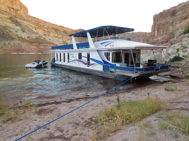 Slide: The Image of 2003 Stardust Cruisers Summer Haven Share #34 & 35 houseboat docked by rocky shore. - 2
