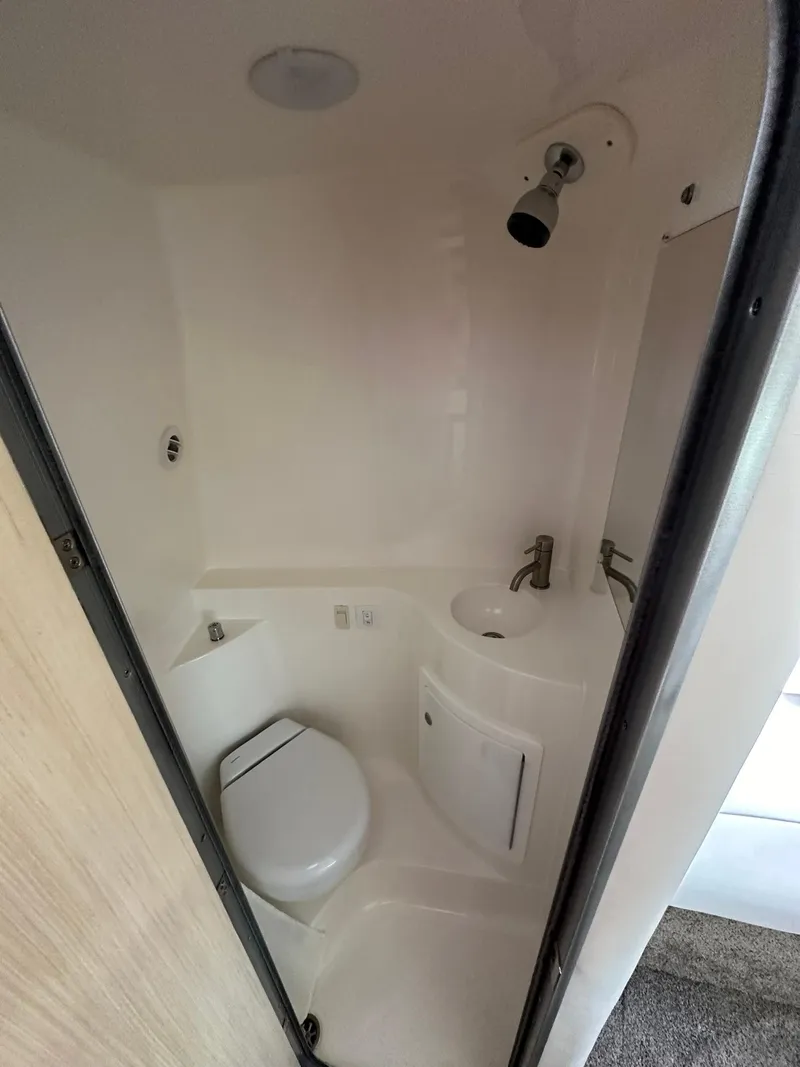 Slide: The Image of 2025 Regal 26XO cabin interior with cozy bed and wooden door. - 23