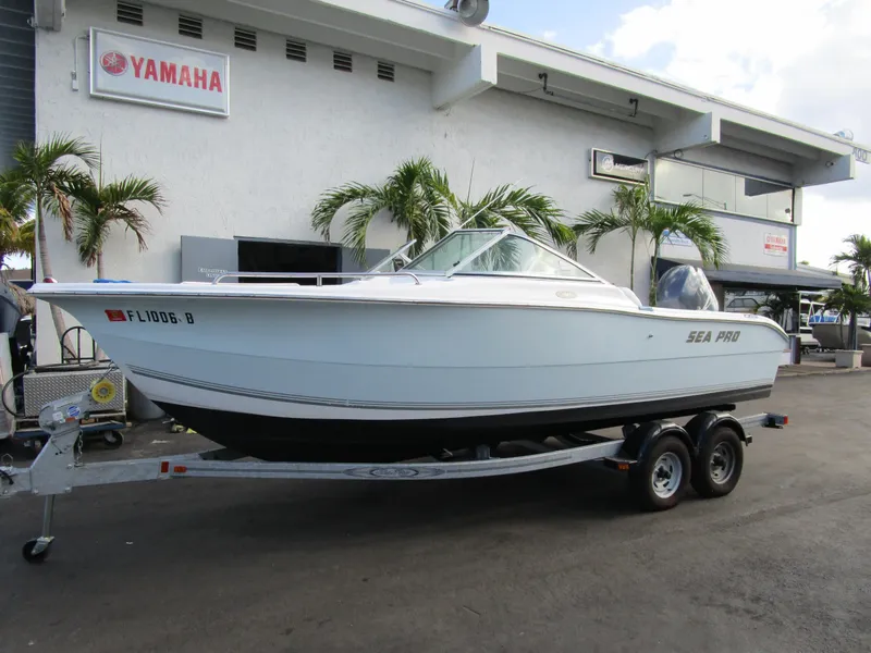 The Image of 2006 Sea Pro 206 Dual Console boat on trailer, parked outside Yamaha dealership. - 0