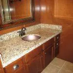 Slide: The Image of 2011 Bravada Knot A Problem #3 & 9 bathroom with granite countertop and wooden cabinets. - 10