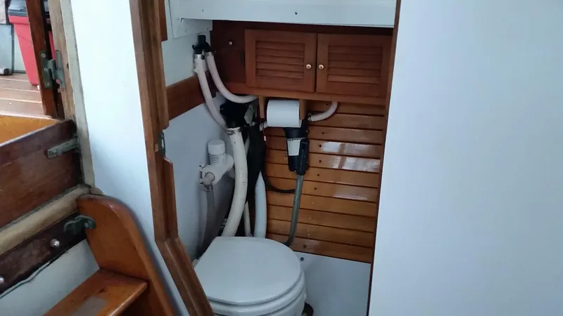 Slide: The Image of Boat bathroom with wooden paneling, compact toilet, and storage cabinet. Frans Maas-LeFevre 1960 model. - 11