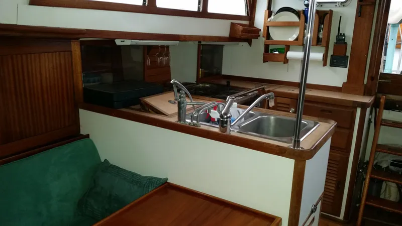 Slide: The Image of Vintage 1960 yacht interior with wooden cabinetry, sink, and green seating. - 3