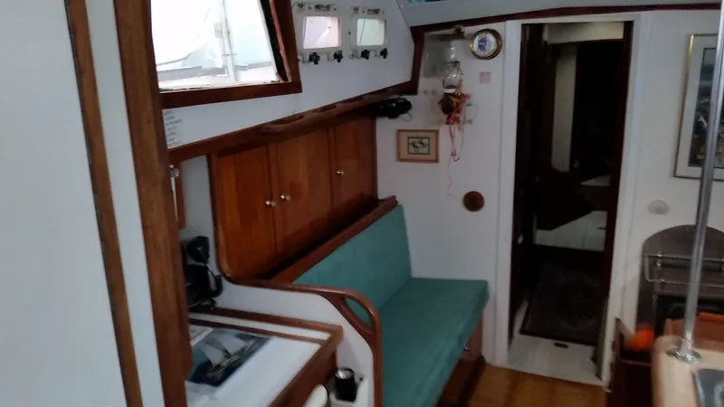 Slide: The Image of Interior of 1960 Frans Maas-LeFevre One Off Custom 47 sailboat, featuring wooden cabinetry and seating. - 8