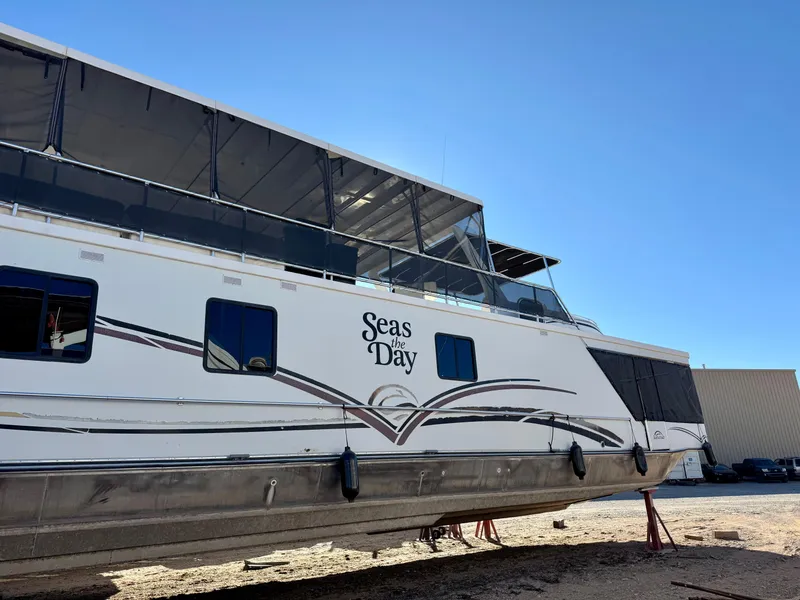Slide: The Image of 2006 Sumerset Seas The Day Trip 11 houseboat on dry dock under clear blue sky. - 39