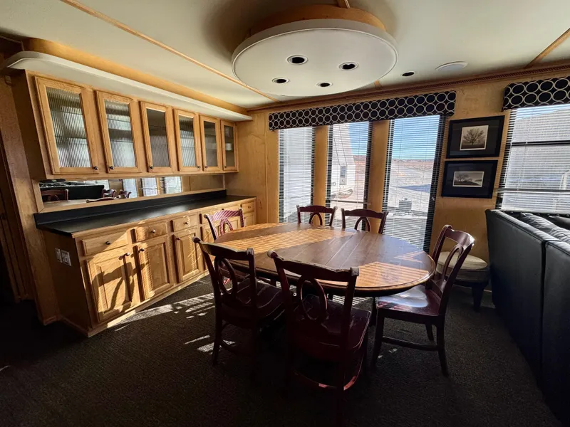 Slide: The Image of Dining area in 2006 Sumerset Seas The Day Trip 11 houseboat with wooden cabinetry and large windows. - 7