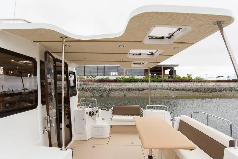 Slide: The Image of 2024 Ranger Tugs R-31 Sedan Luxury Edition boat deck with seating and table. - 10