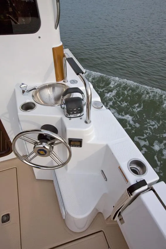 Slide: The Image of 2024 Ranger Tugs R-31 Sedan Luxury Edition helm station with sink and steering wheel. - 13