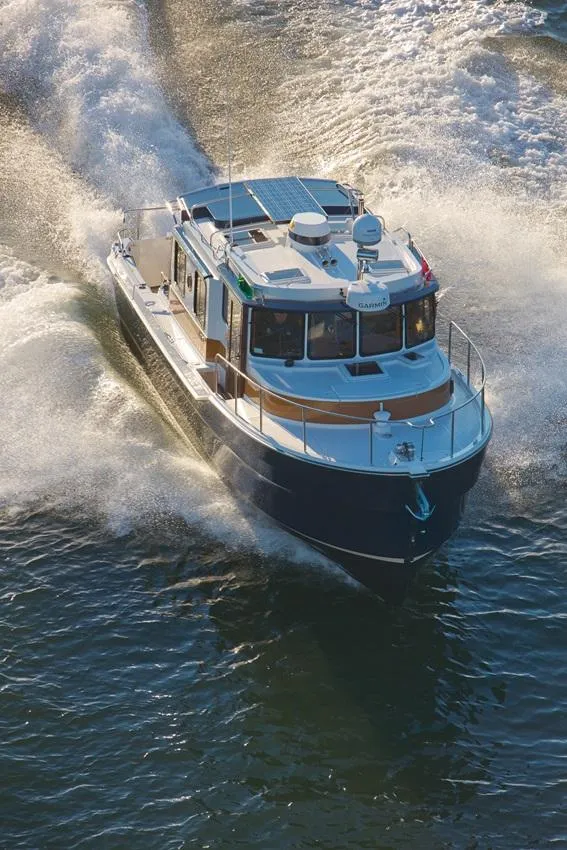 Slide: The Image of 2024 Ranger Tugs R-31 Sedan Luxury Edition cruising on water. - 18