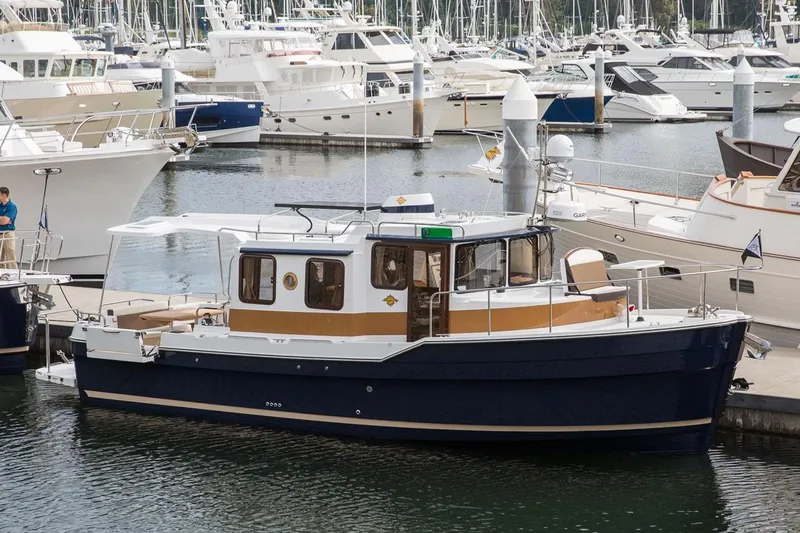 Slide: The Image of 2024 Ranger Tugs R-31 Sedan Luxury Edition docked in a marina. - 2