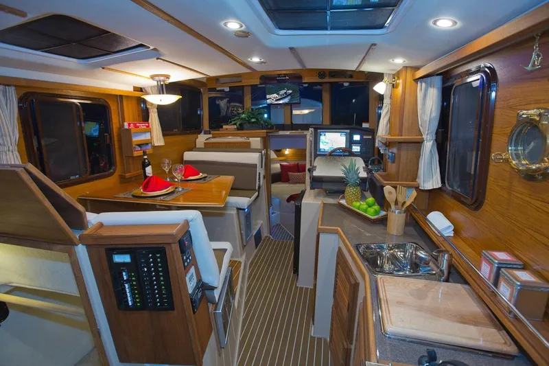 Slide: The Image of Interior of 2024 Ranger Tugs R-31 Sedan Luxury Edition yacht, featuring dining and kitchen areas. - 20