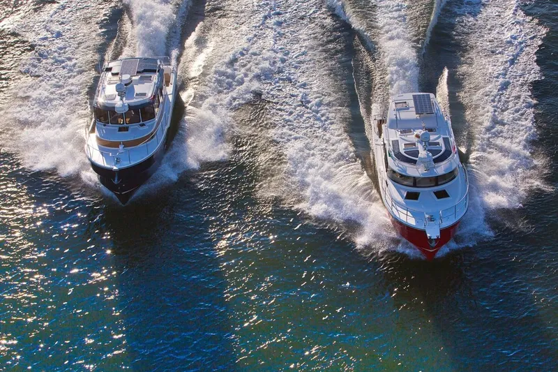 Slide: The Image of Two 2024 Ranger Tugs R-31 Sedan Luxury Edition boats cruising on water. - 31