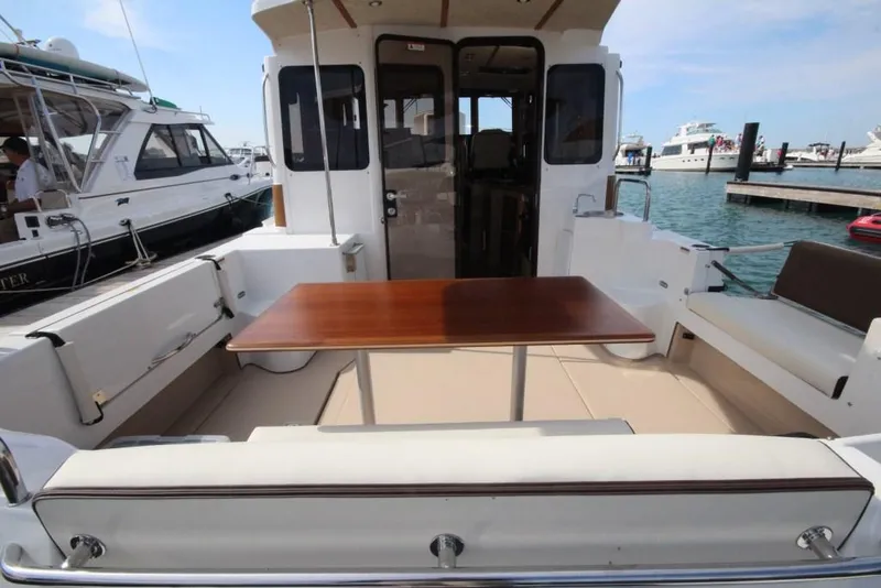 Slide: The Image of 2024 Ranger Tugs R-31 Sedan Luxury Edition boat deck with seating and table. - 43
