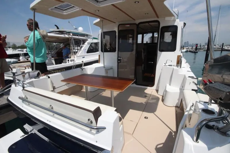 Slide: The Image of 2024 Ranger Tugs R-31 Sedan Luxury Edition boat with spacious deck and wooden table. - 44