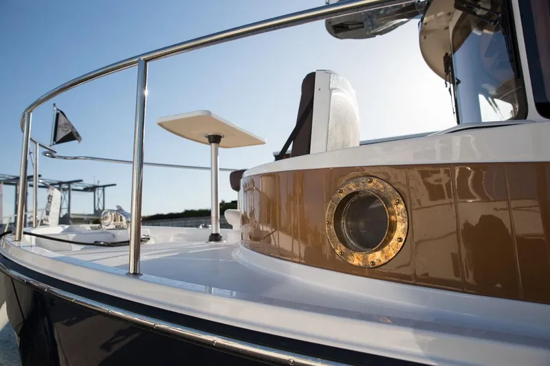 Slide: The Image of 2024 Ranger Tugs R-31 Sedan Luxury Edition boat deck with porthole and railing. - 7