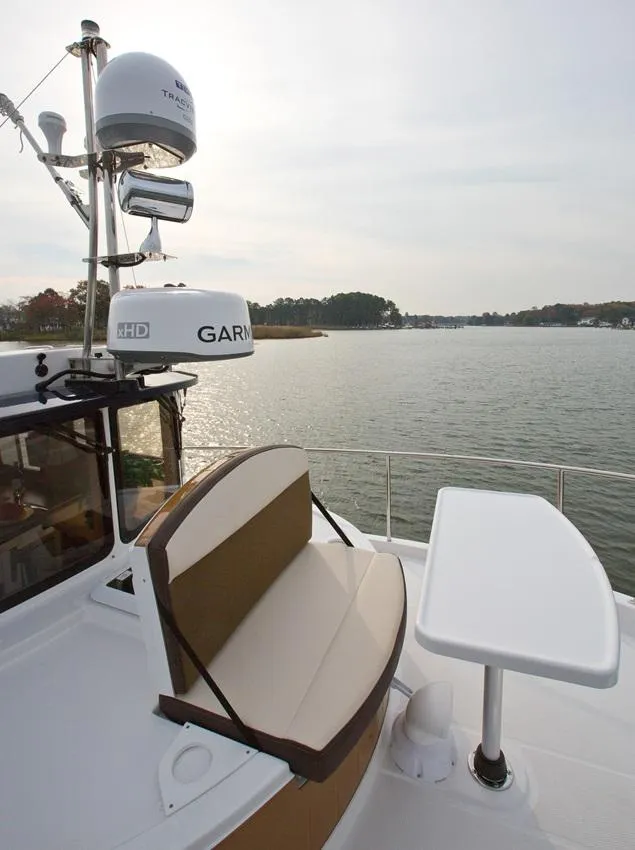 Slide: The Image of 2024 Ranger Tugs R-31 Sedan Luxury Edition boat with outdoor seating and table. - 15