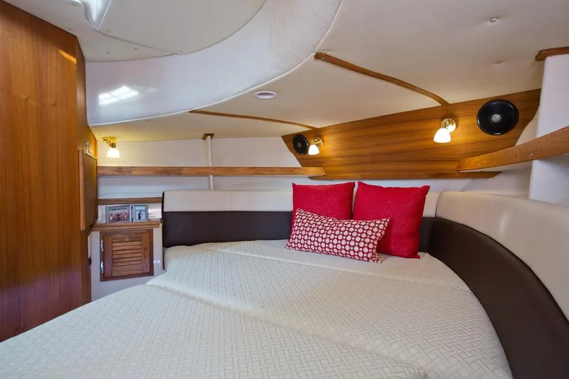 Slide: The Image of 2024 Ranger Tugs R-31 Sedan Luxury Edition bedroom with cozy bedding and ambient lighting. - 23