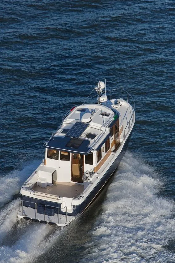 Slide: The Image of 2024 Ranger Tugs R-31 Sedan Luxury Edition cruising on open water. - 25