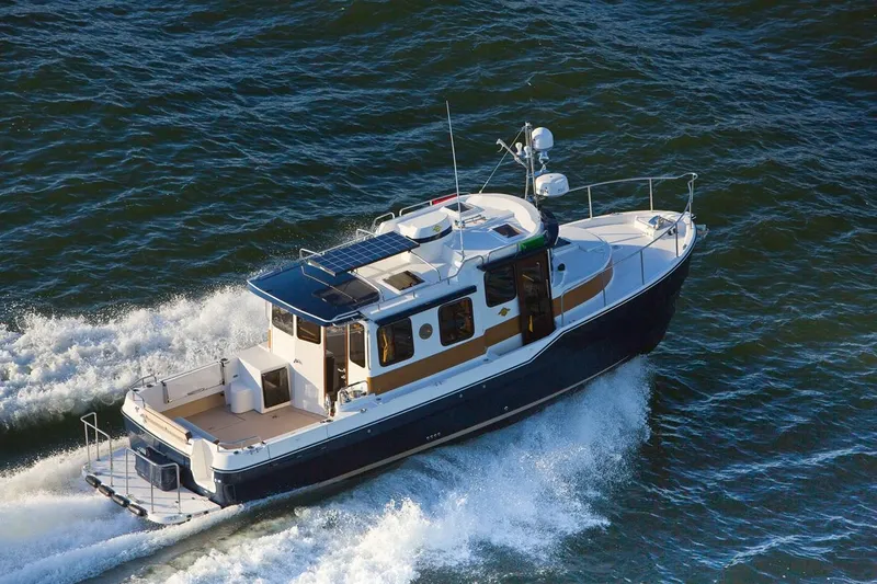 Slide: The Image of 2024 Ranger Tugs R-31 Sedan Luxury Edition cruising on water. - 26