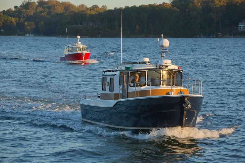 Slide: The Image of 2024 Ranger Tugs R-31 Sedan Luxury Edition cruising on a scenic lake. - 28