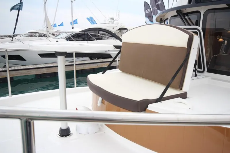 Slide: The Image of 2024 Ranger Tugs R-31 Sedan Luxury Edition boat seating area at marina. - 38