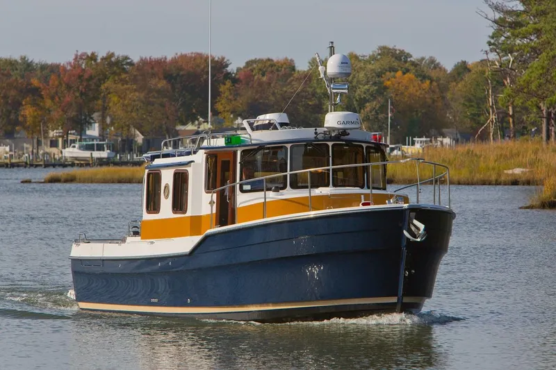 Slide: The Image of 2024 Ranger Tugs R-31 Sedan Luxury Edition cruising on a calm river. - 4