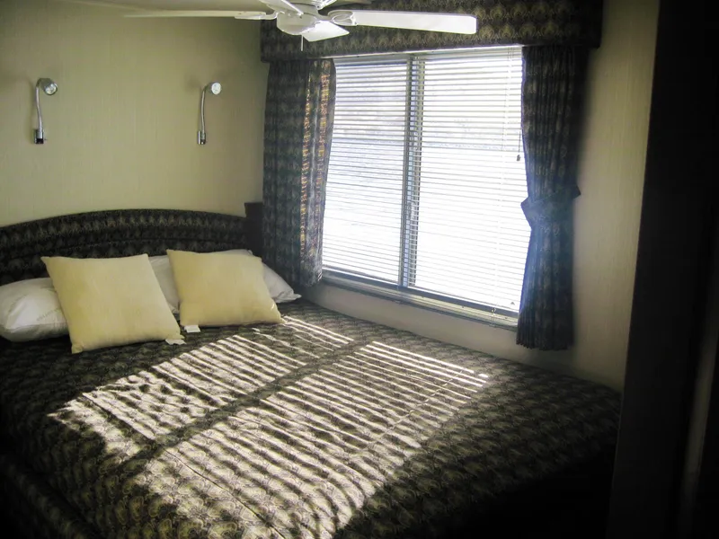 Slide: The Image of Cozy bedroom in 2004 Skipperliner Dream Chaser Group C with patterned bedding and window blinds. - 12