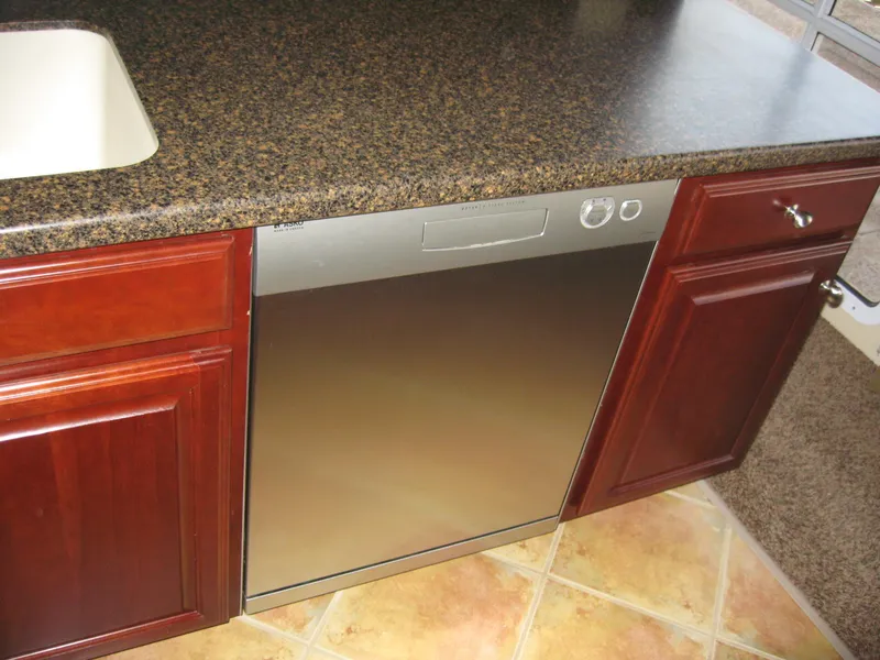 Slide: The Image of Modern kitchen with stainless steel dishwasher, granite countertop, and wooden cabinets. - 14