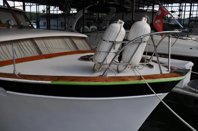 Slide: The Image of 1960 Chris-Craft Roamer boat docked, featuring wooden trim and life rafts on deck. - 10