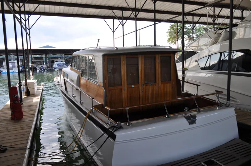 Slide: The Image of 1960 Chris-Craft Roamer docked in a marina, showcasing classic wooden cabin design. - 13