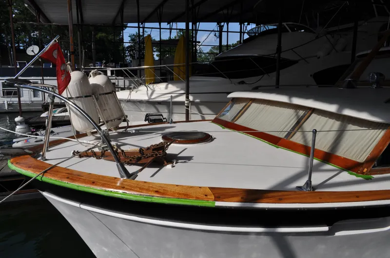 Slide: The Image of 1960 Chris-Craft Roamer boat docked in a marina under a covered structure. - 15