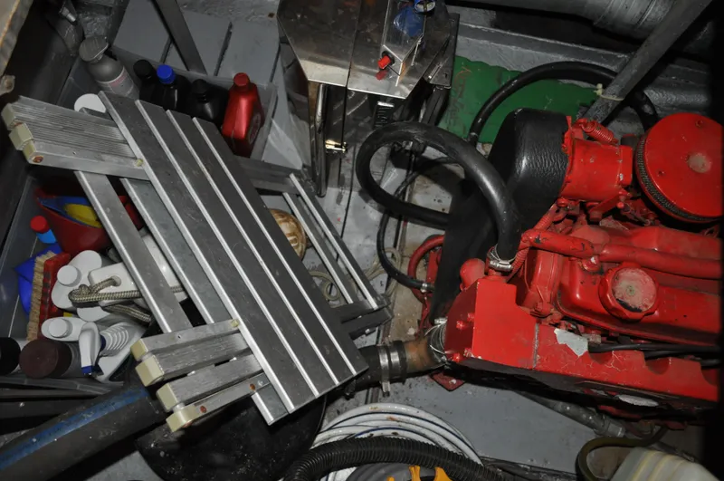 Slide: The Image of 1960 Chris-Craft Roamer engine room with red engine, ladder, and various tools. - 18