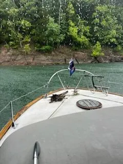 Slide: The Image of 1960 Chris-Craft Roamer boat on a serene lake with lush green shoreline. - 38