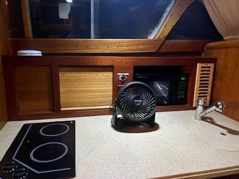 Slide: The Image of 1960 Chris-Craft Roamer kitchen with stove, fan, microwave, and sink. - 39