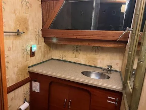 Slide: The Image of 1960 Chris-Craft Roamer bathroom with wood accents and palm tree wallpaper. - 41
