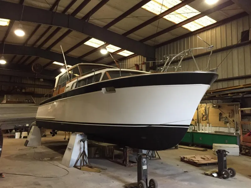 Slide: The Image of 1960 Chris-Craft Roamer boat in a warehouse, undergoing maintenance. - 5