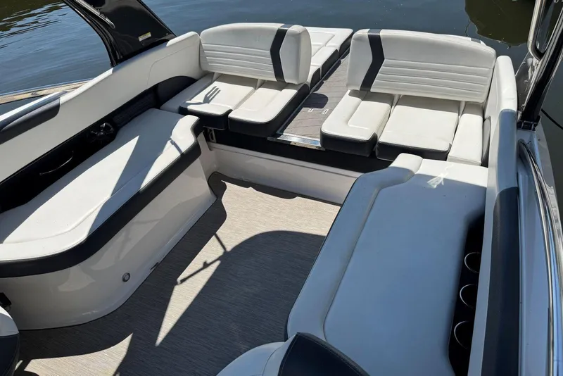 Slide: The Image of 2017 Regal 2500 Bowrider interior with white seating and cup holders, docked on water. - 5
