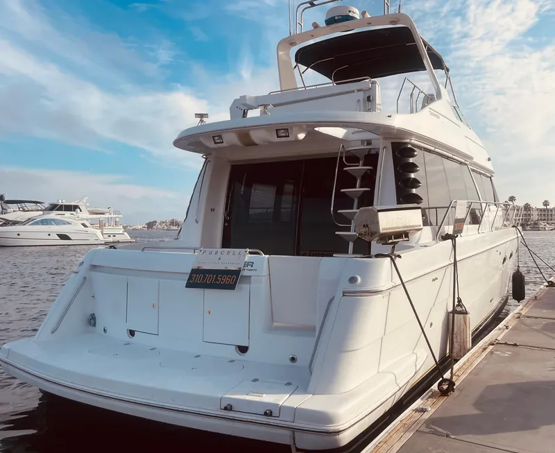 Slide: The Image of 1999 Carver Voyager yacht docked at marina under blue sky. - 1