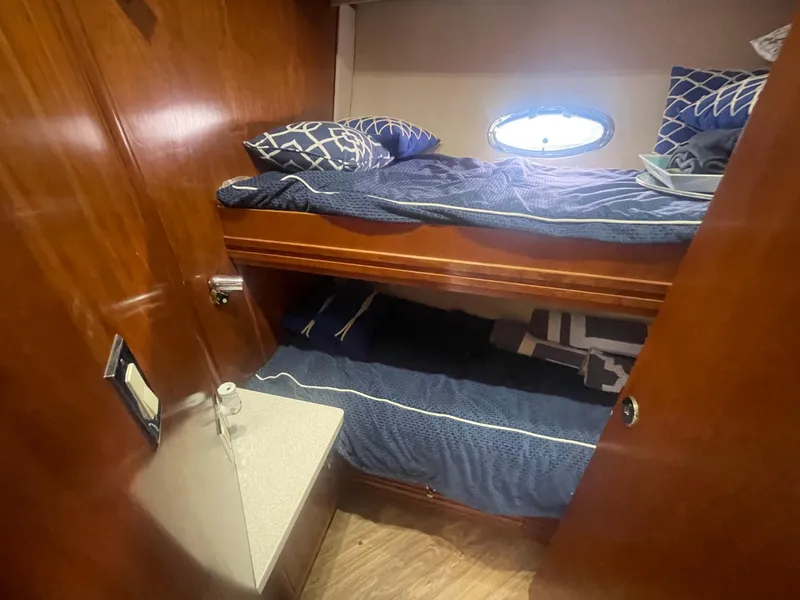 Slide: The Image of 1999 Carver Voyager cabin with wooden interior, bunk beds, and a small window. - 24