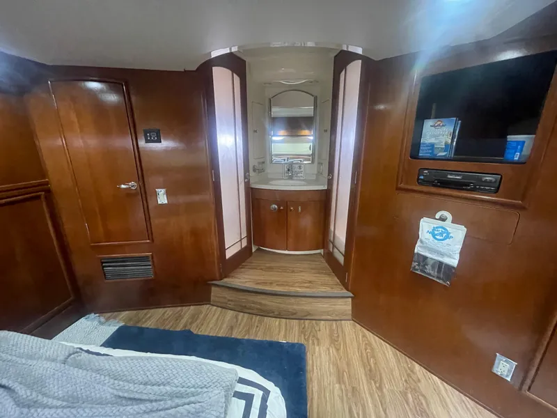 Slide: The Image of Luxurious 1999 Carver Voyager interior with wood finish, featuring a vanity and entertainment area. - 25